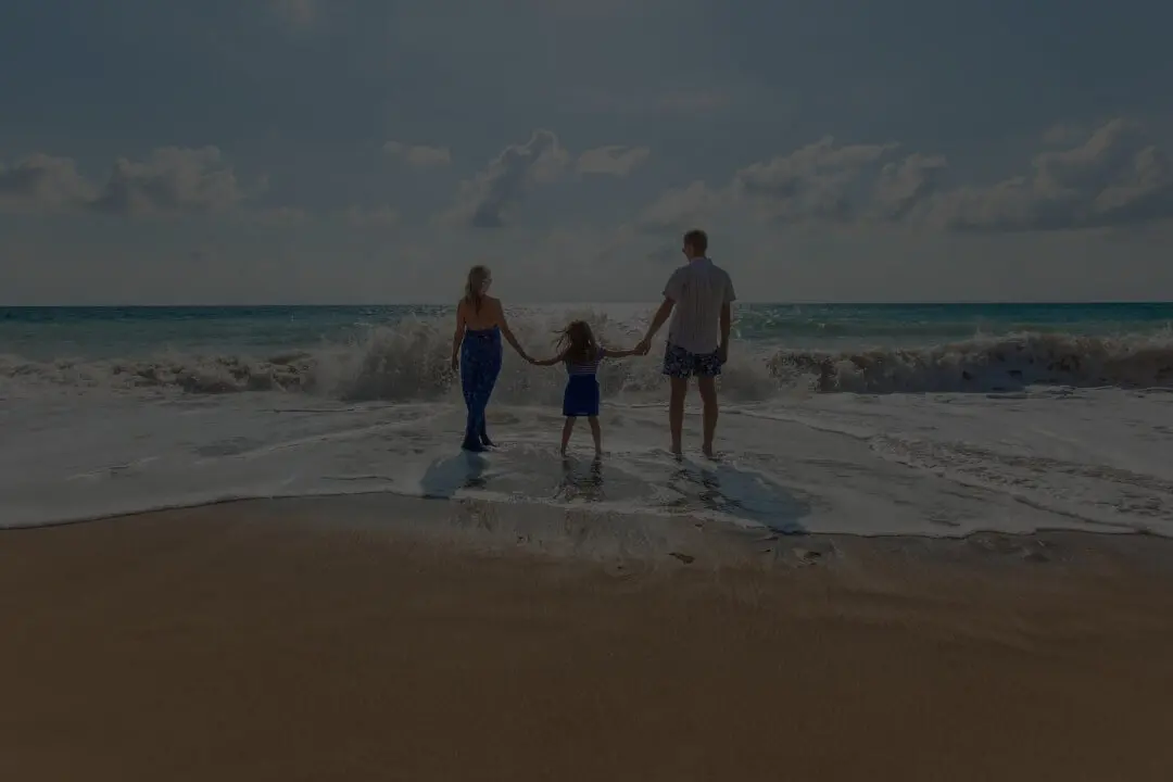 Familie mit Kind am Strand mit Wellen
