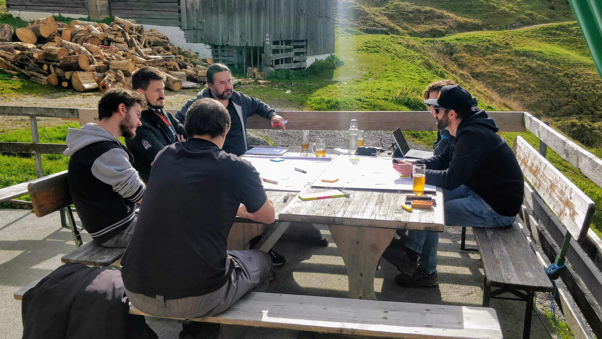 Eine Gruppe von Männern bei einem Workshop an einem Tisch im Freien